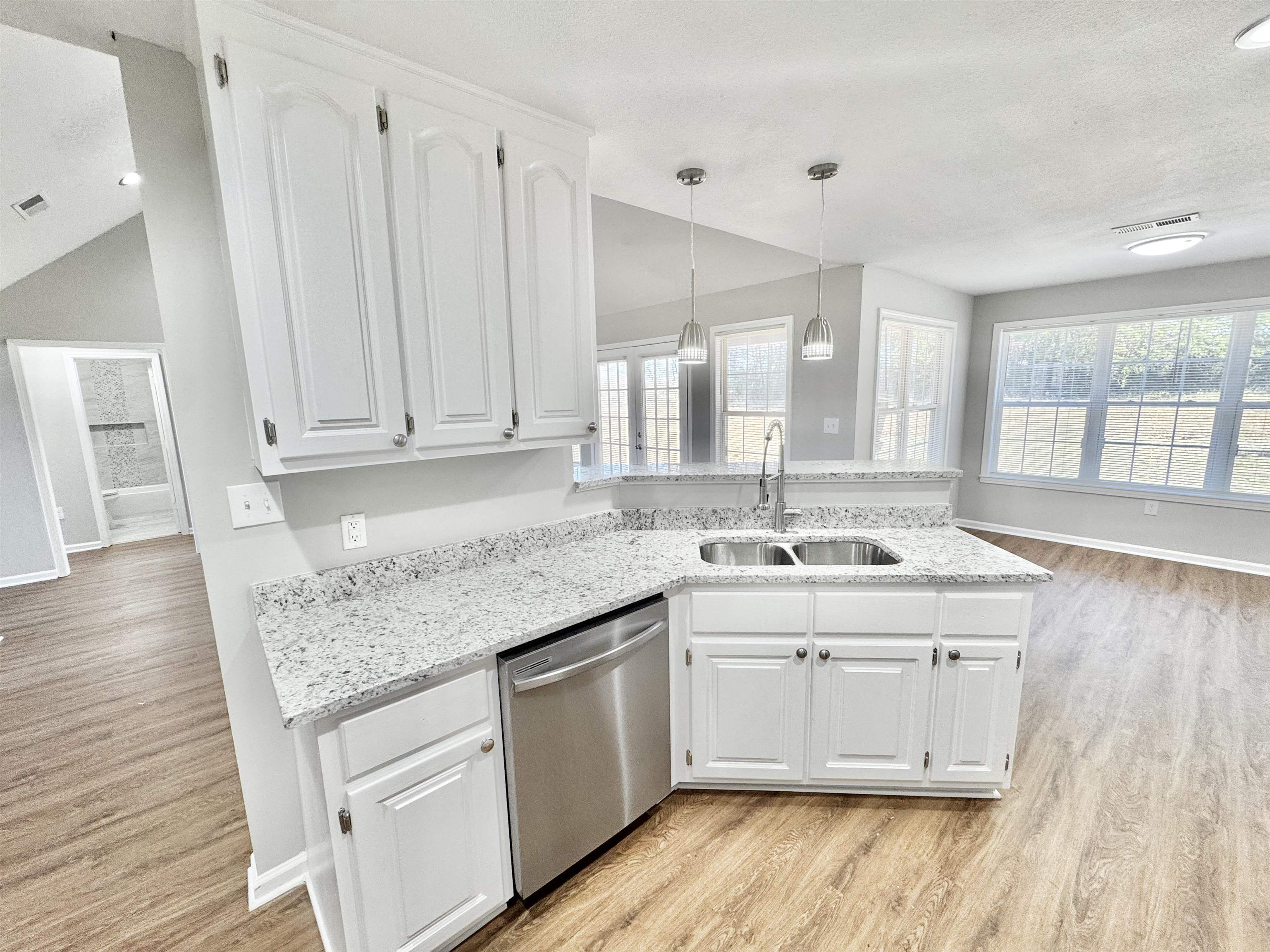 788 Bruce Road Whiteville, TN 38075 - Photo 7 of 39 Kitchen with a peninsula, light stone countertops, white cabinetry, and a textured ceiling
