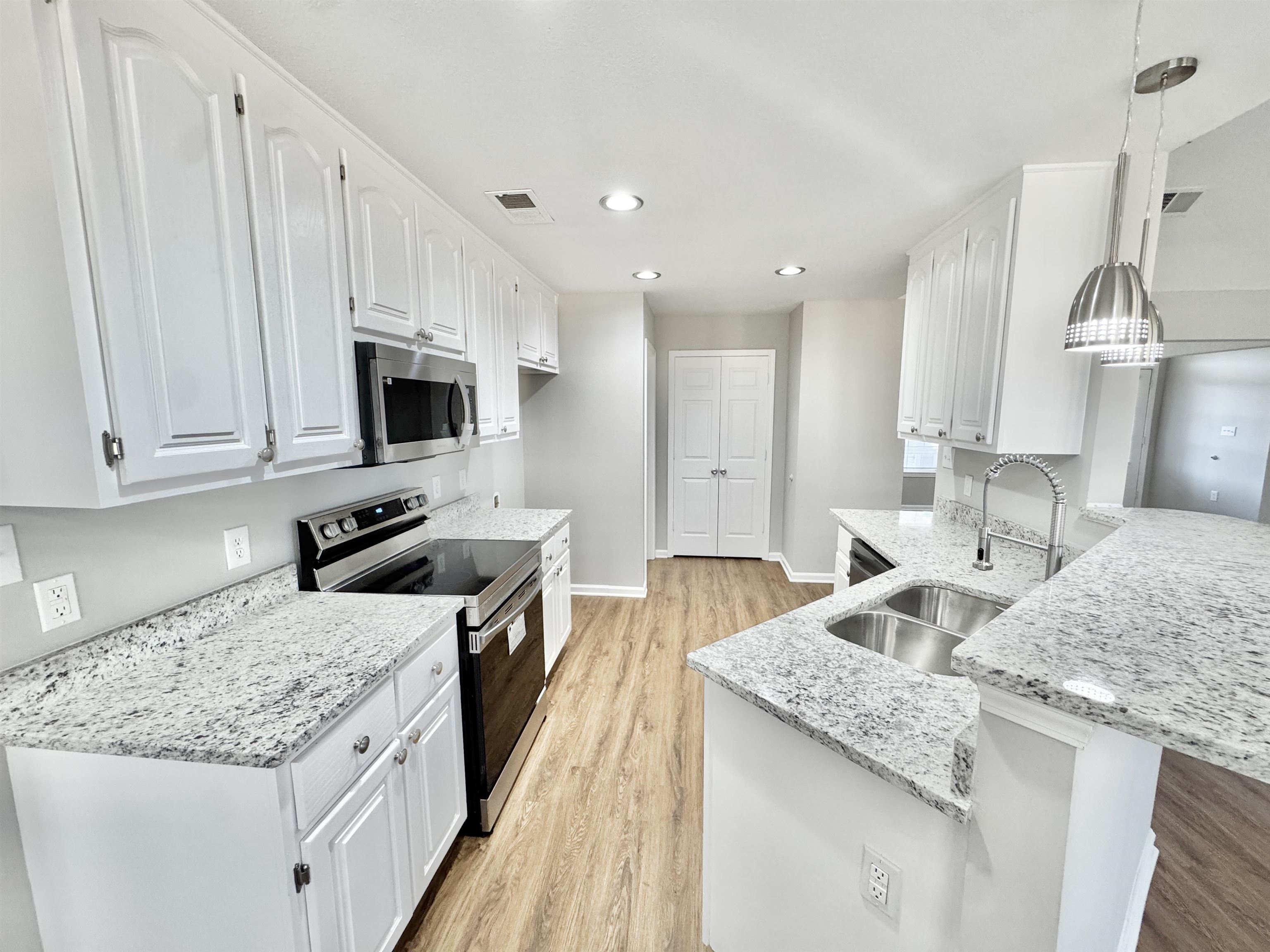 788 Bruce Road Whiteville, TN 38075 - Photo 8 of 39 Kitchen featuring appliances with stainless steel finishes, decorative light fixtures, light stone countertops, white cabinets, and recessed lighting
