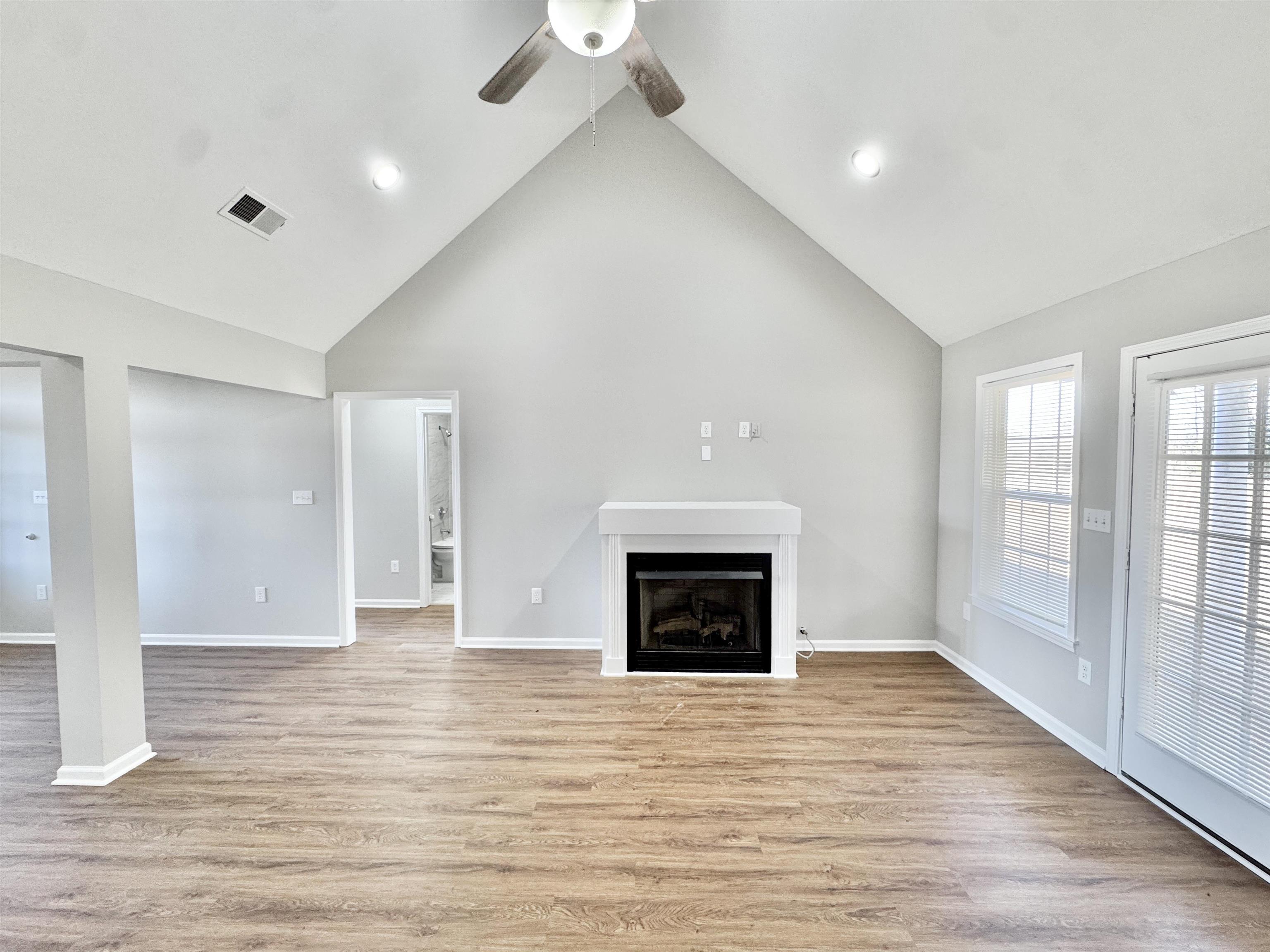 788 Bruce Road Whiteville, TN 38075 - Photo 10 of 39 Unfurnished living room featuring high vaulted ceiling, light wood finished floors, a fireplace, and a ceiling fan