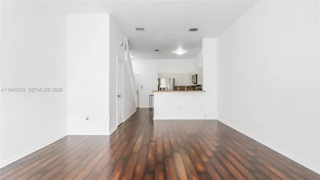 a view of a kitchen with wooden floor and electronic appliances