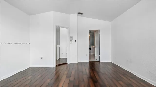 an empty room with wooden floor and closet