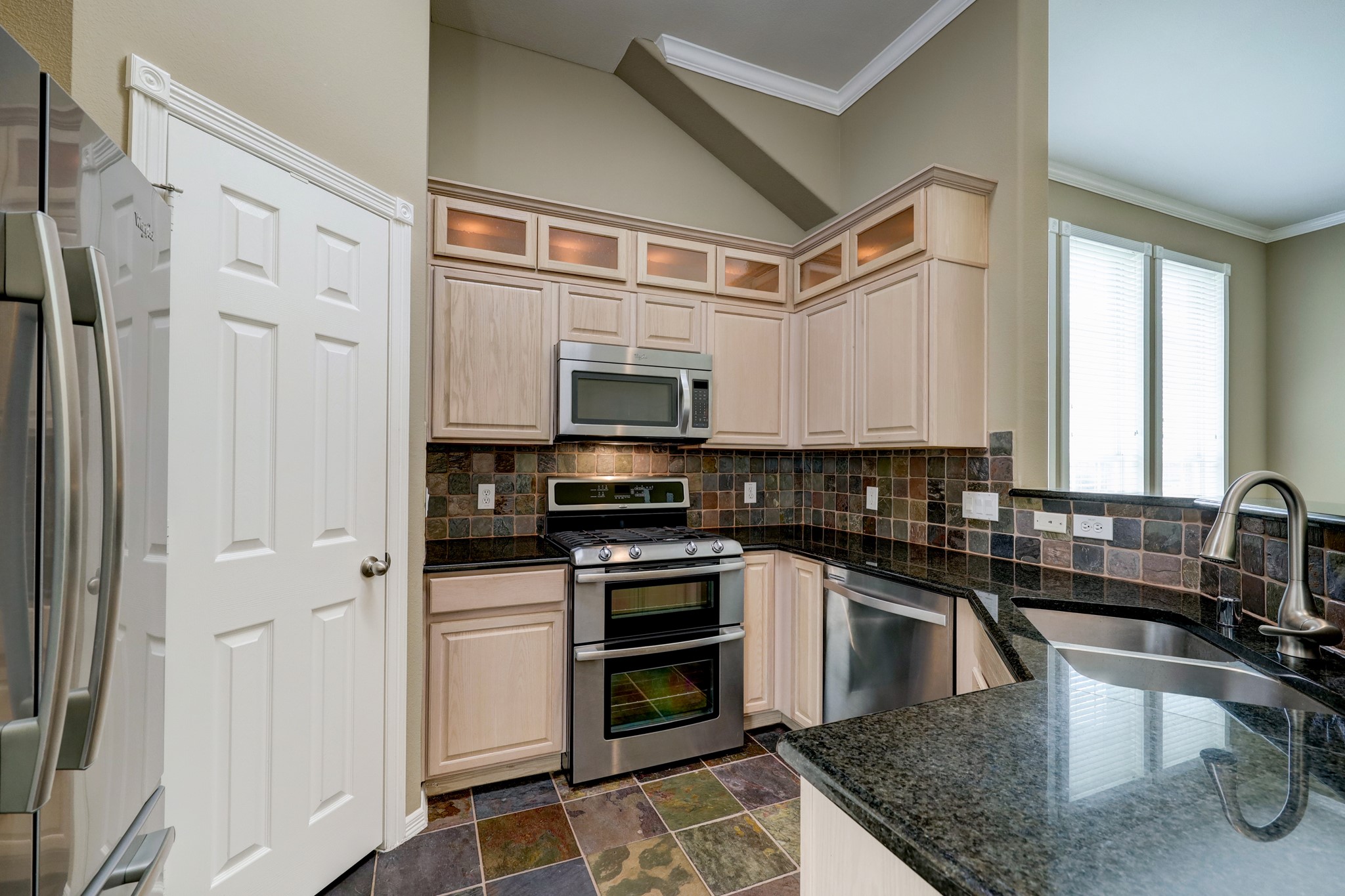 18618 Jaya Loch Court Spring, TX 77379 - Photo 9 of 18 a kitchen with stainless steel appliances granite countertop a stove a sink and a microwave