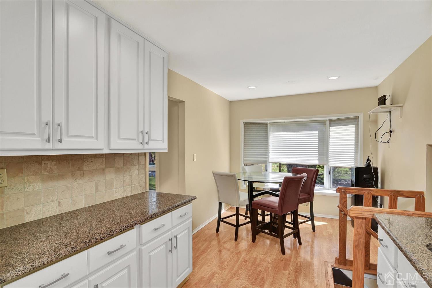 8 Innes Road East Brunswick, NJ 08816 - Photo 12 of 32 a kitchen with granite countertop white cabinets dining table and chairs