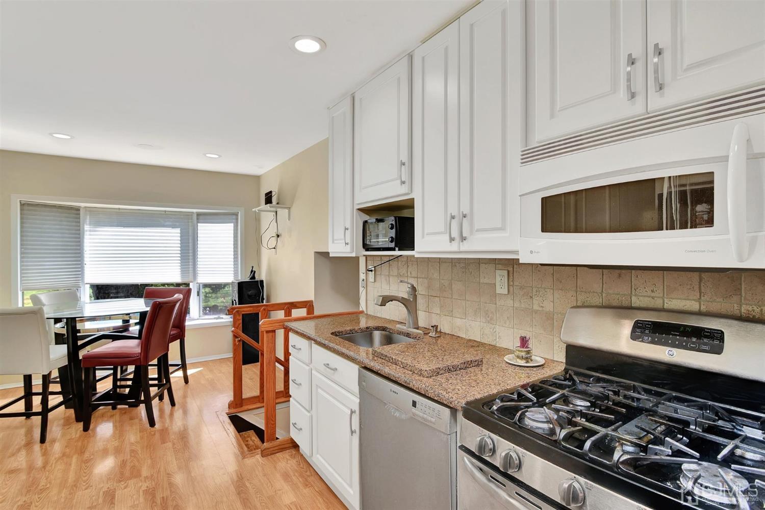 8 Innes Road East Brunswick, NJ 08816 - Photo 10 of 32 a kitchen with stainless steel appliances a stove a sink dishwasher and a microwave oven with wooden floor
