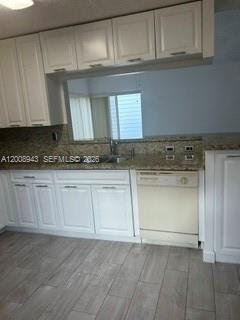 13716 Southwest 149th Cir Lane, Unit 461 Miami, FL 33186 - Photo 3 of 9 a kitchen with granite countertop white cabinets and a stove