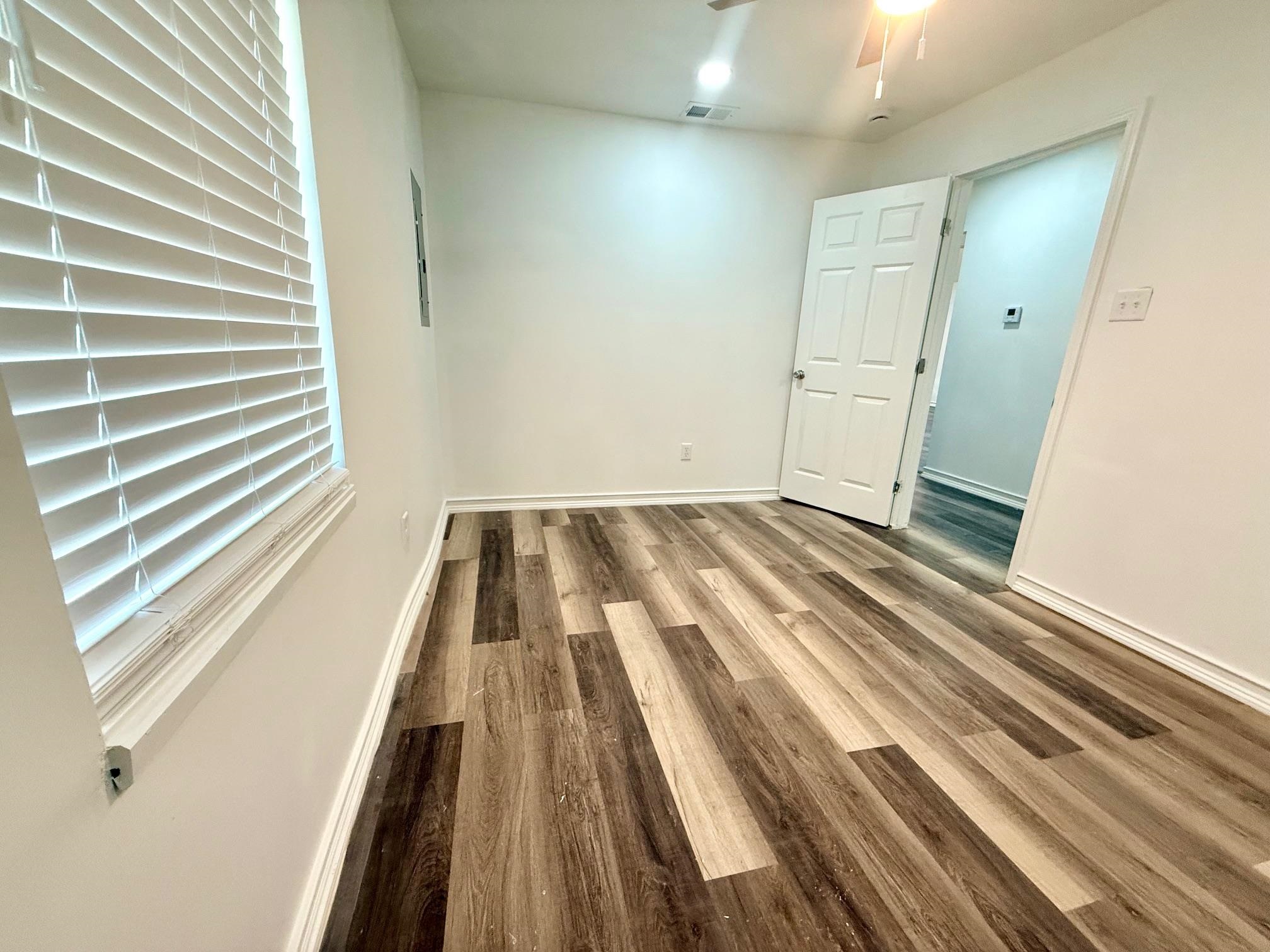3054 Lotus Road Memphis, TN 38109 - Photo 21 of 29 Spacious room featuring wood-finish flooring, white walls, and a ceiling fan with integrated lighting
