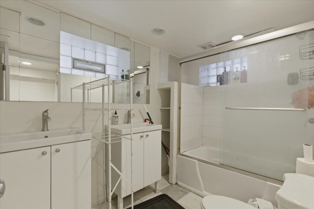 3716 North Wayne Avenue, Unit GR Chicago, IL 60613 - Photo 10 of 10 a bathroom with a shower sink and mirror