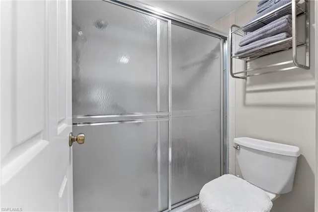 a bathroom with a toilet and a glass shower door