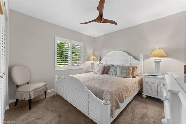 a bedroom with a bed a chandelier and window