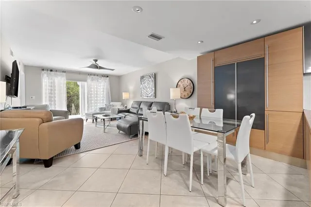 a living room with furniture a large window and a dining table