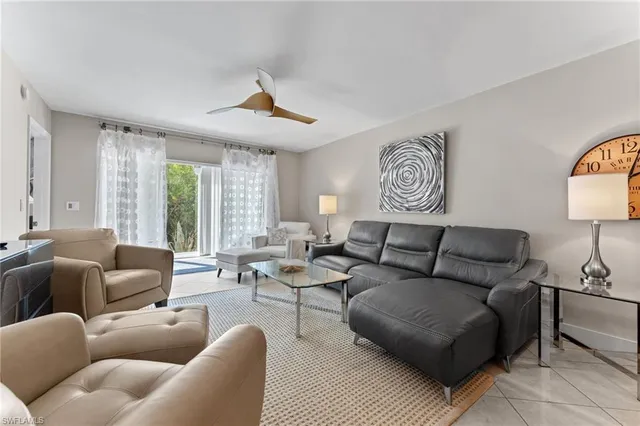 a living room with furniture ceiling fan and a window