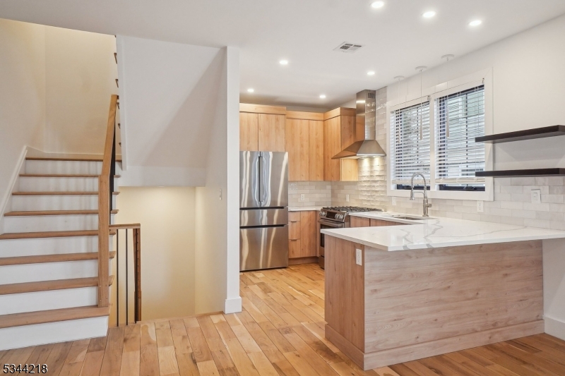 51 New Street, Unit B Montclair, NJ 07042 - Photo 7 of 32 a kitchen with stainless steel appliances granite countertop a refrigerator a sink dishwasher a stove and a refrigerator with wooden floor