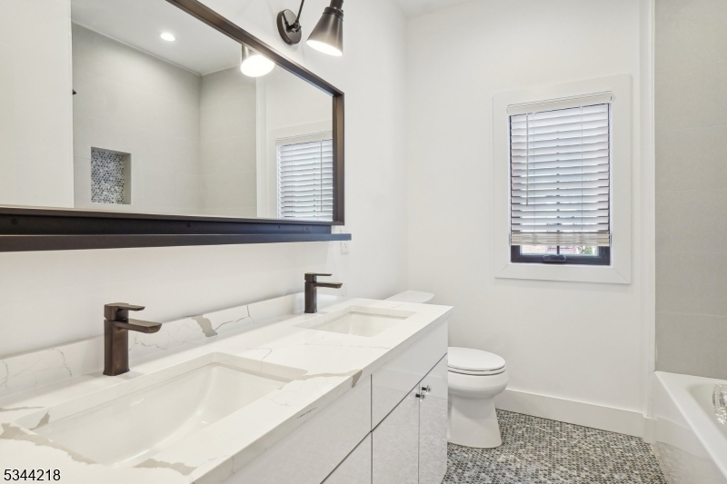 51 New Street, Unit B Montclair, NJ 07042 - Photo 9 of 32 a bathroom with a sink a toilet and mirror