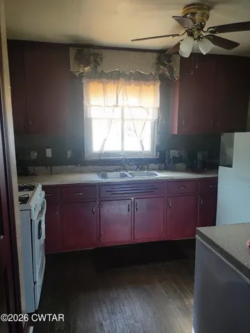 a kitchen with granite countertop a sink a stove and a microwave