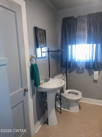 a bathroom with a toilet a sink and a mirror