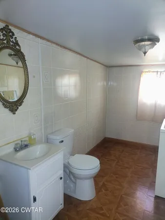 a bathroom with a granite countertop toilet a sink and mirror