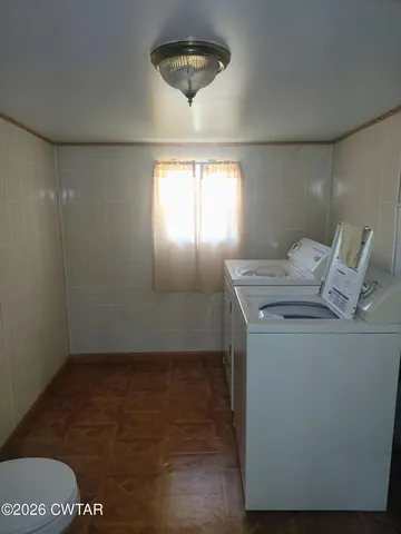 a room with water heater and wooden cabinets