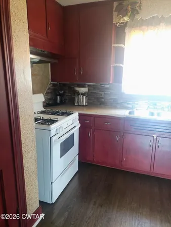 a kitchen with granite countertop stainless steel appliances a stove a sink and a microwave