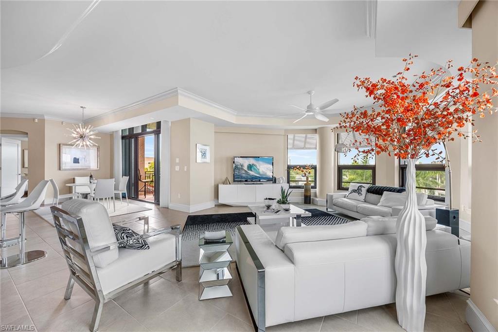 9115 Strada Place, Unit 5416 Naples, FL 34108 - Photo 10 of 44 Living room featuring ornamental molding, plenty of natural light, light tile patterned floors, a chandelier, and a ceiling fan