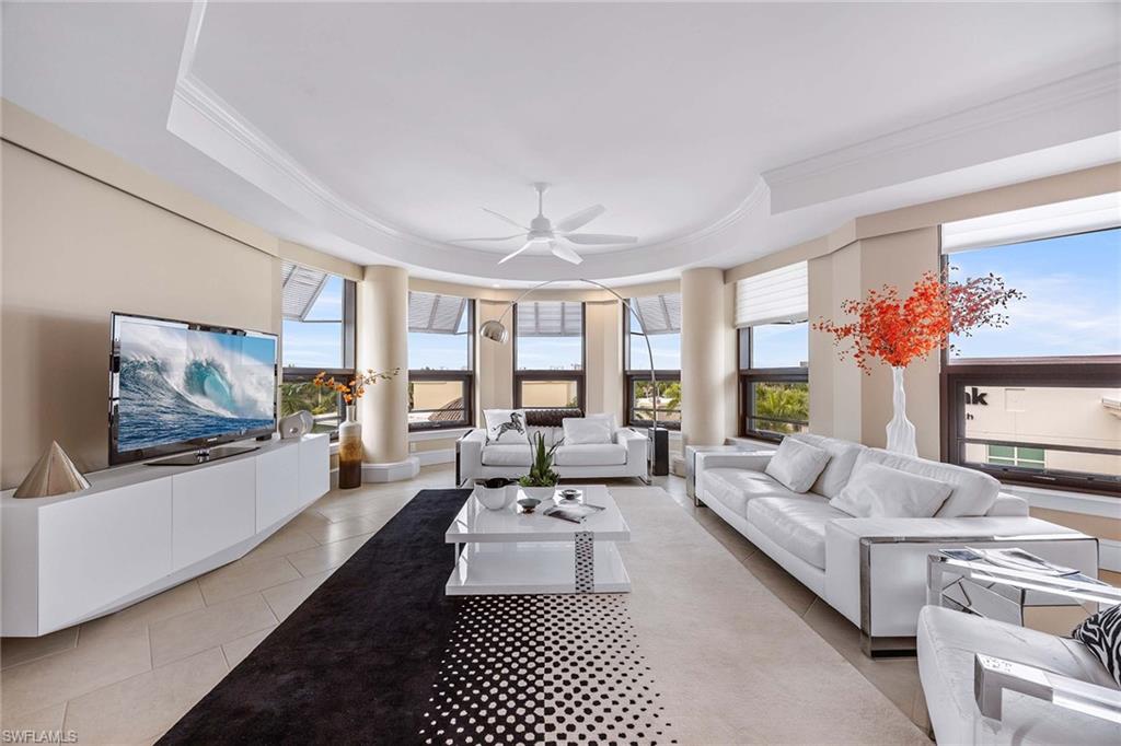 9115 Strada Place, Unit 5416 Naples, FL 34108 - Photo 3 of 44 Living room featuring ornamental molding, a raised ceiling, light tile patterned flooring, healthy amount of natural light, and a ceiling fan