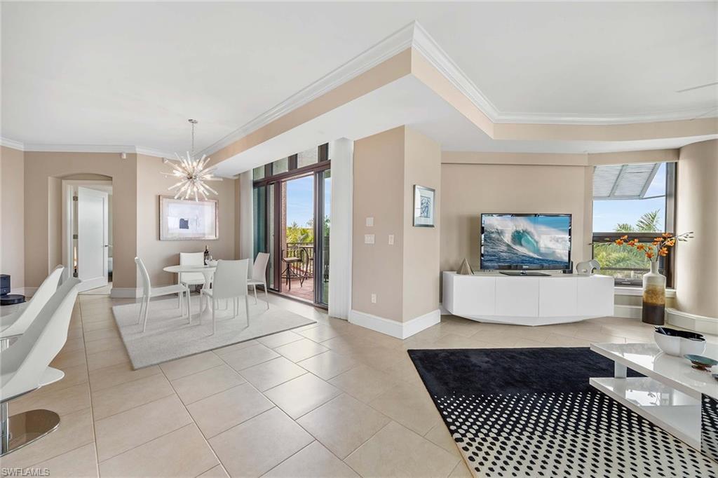 9115 Strada Place, Unit 5416 Naples, FL 34108 - Photo 7 of 44 Living area featuring crown molding, light tile patterned floors, a chandelier, and arched walkways