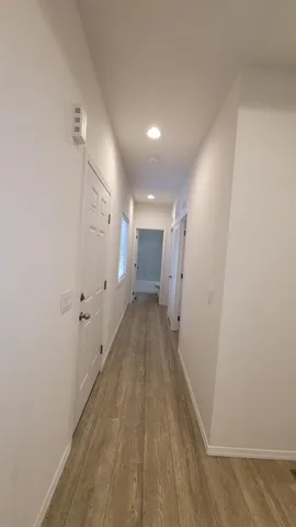 a view of a hallway with wooden floor