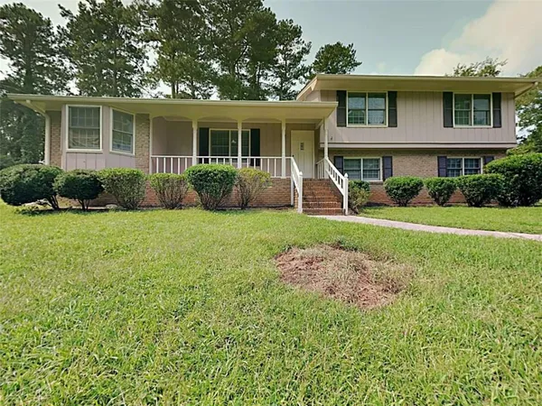 a view of a house with backyard sitting area and garden