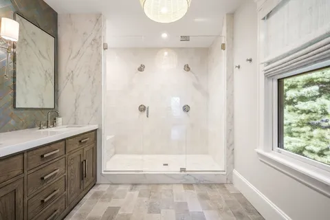 a bathroom with a granite countertop sink a toilet and shower
