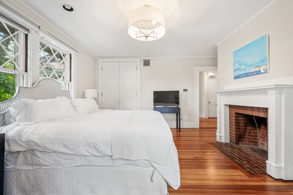 85 Williston Road Brookline, MA 02445 - Photo 17 of 29 a spacious bedroom with a bed and a fireplace