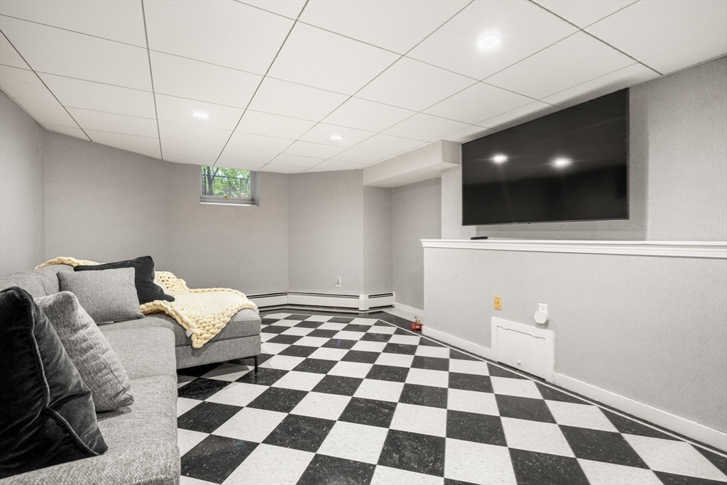 85 Williston Road Brookline, MA 02445 - Photo 21 of 29 a living room with a black white checkered floor with a gaming machine and dining table