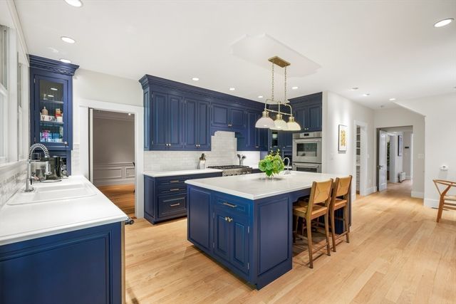 a kitchen with kitchen island granite countertop wooden cabinets and a refrigerator