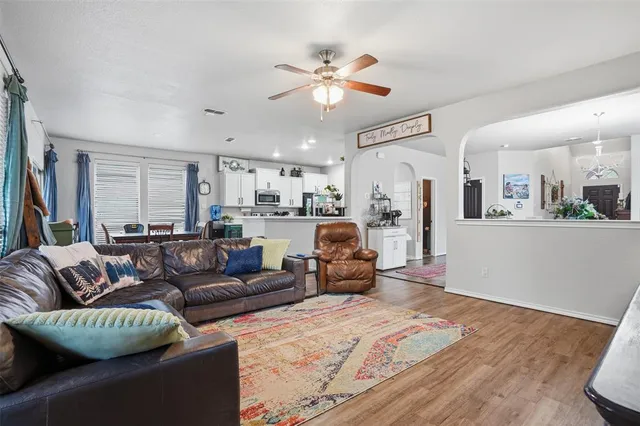 a living room with furniture kitchen view and a chandelier