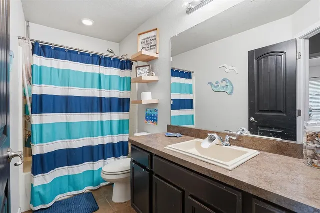 a bathroom with a sink a toilet a shower and a mirror