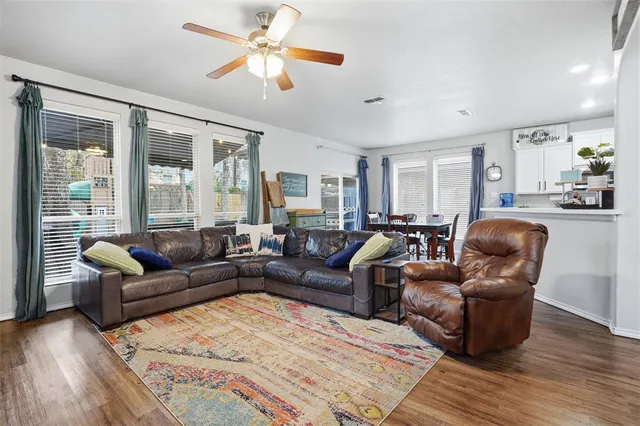 a living room with furniture a ceiling fan and a window