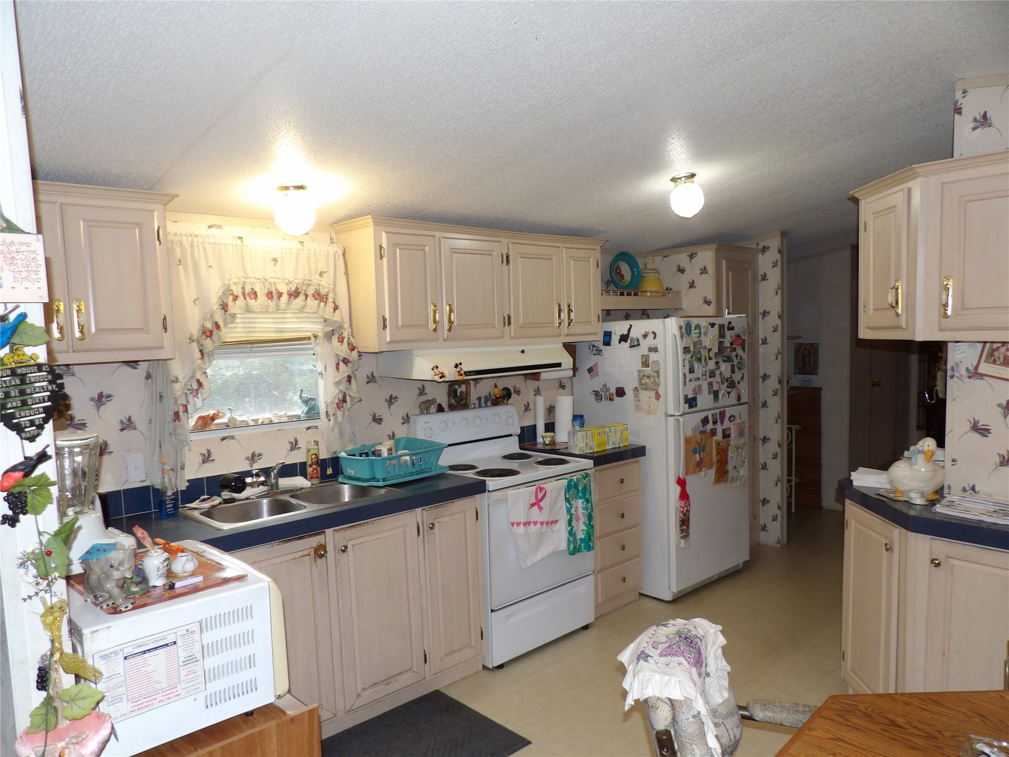 4748 County Road 3220 Kempner, TX 76539 - Photo 4 of 17 a kitchen with refrigerator a stove a sink and white cabinets