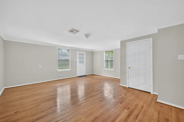 an empty room with a window and wooden floor