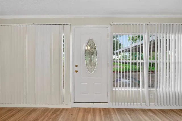 a view of an empty room with wooden floor fireplace and a window
