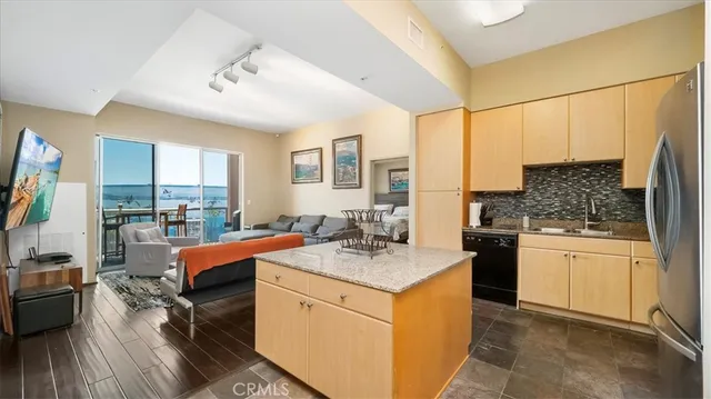 a kitchen with stainless steel appliances granite countertop a stove top oven a sink dishwasher and white cabinets with wooden floor