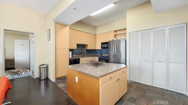 a kitchen with stainless steel appliances granite countertop a refrigerator and a sink