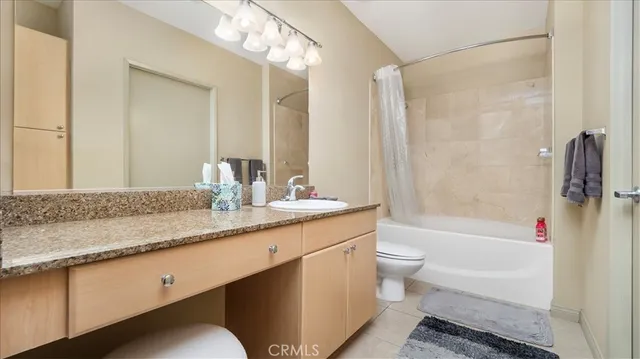 a bathroom with a granite countertop sink a toilet and shower