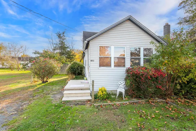 a front view of a house with a garden and yard