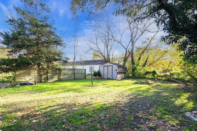a tall yellow house in middle of the forest