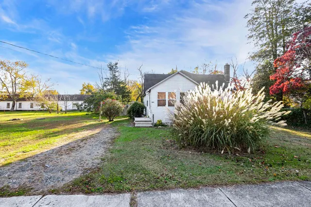 a view of a house with a yard and potted plants