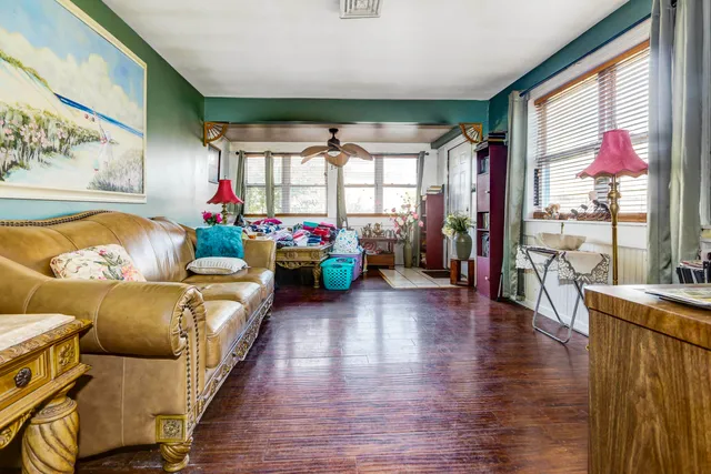 a living room with furniture a flat screen tv and a floor to ceiling window