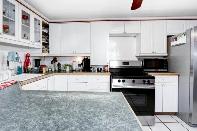 a kitchen with stainless steel appliances granite countertop a stove a sink and a refrigerator