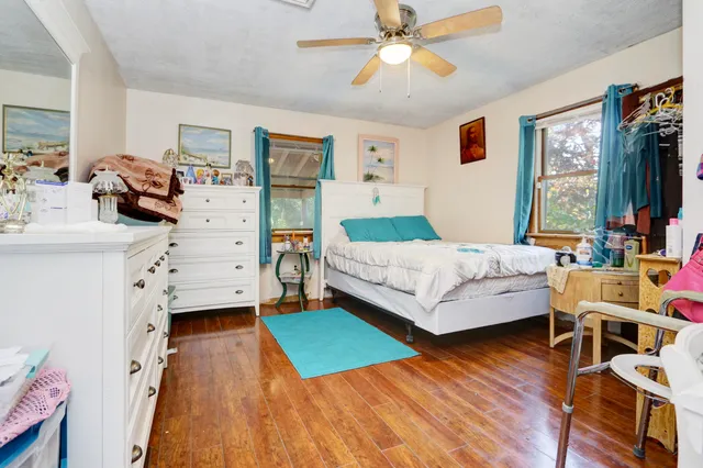 a bedroom with a bed and a wooden floor