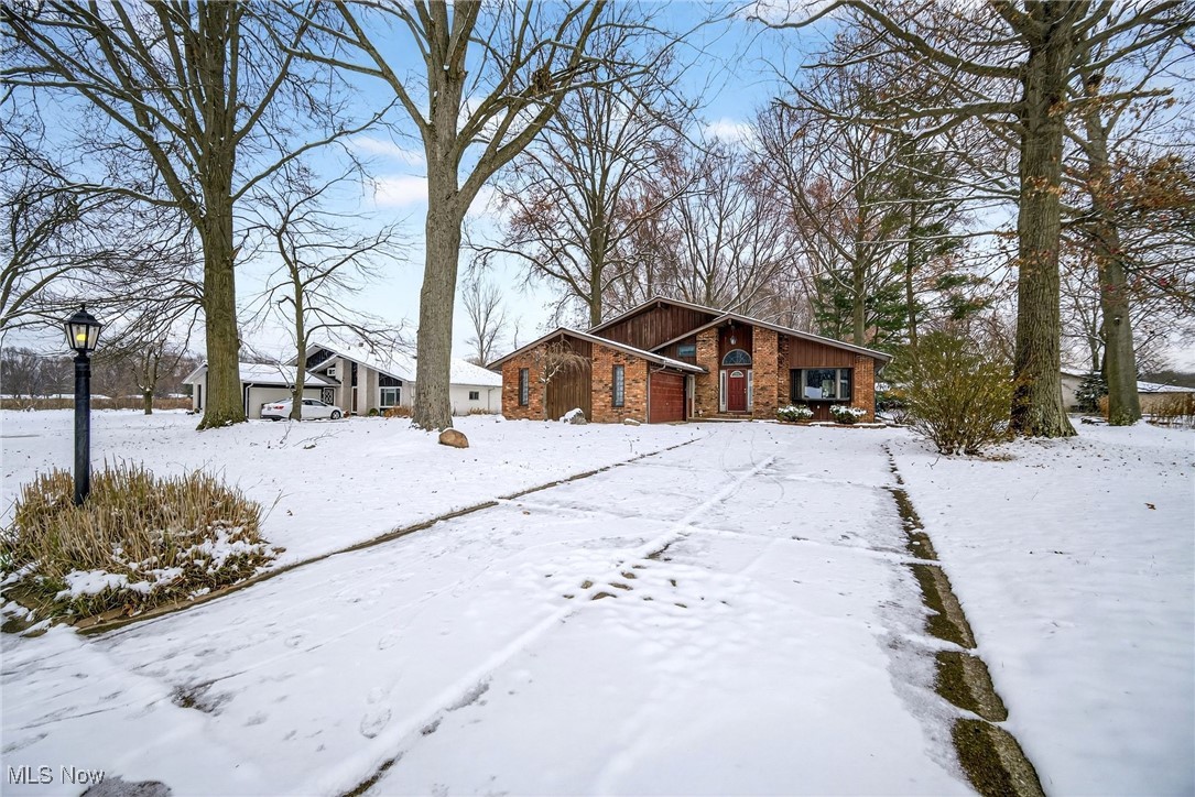 6379 Cary Road North Ridgeville, OH 44039 - Photo 2 of 29 View of snowy exterior with brick siding and board and batten siding