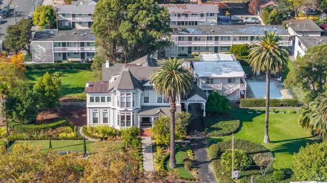 an aerial view of multiple houses with a yard