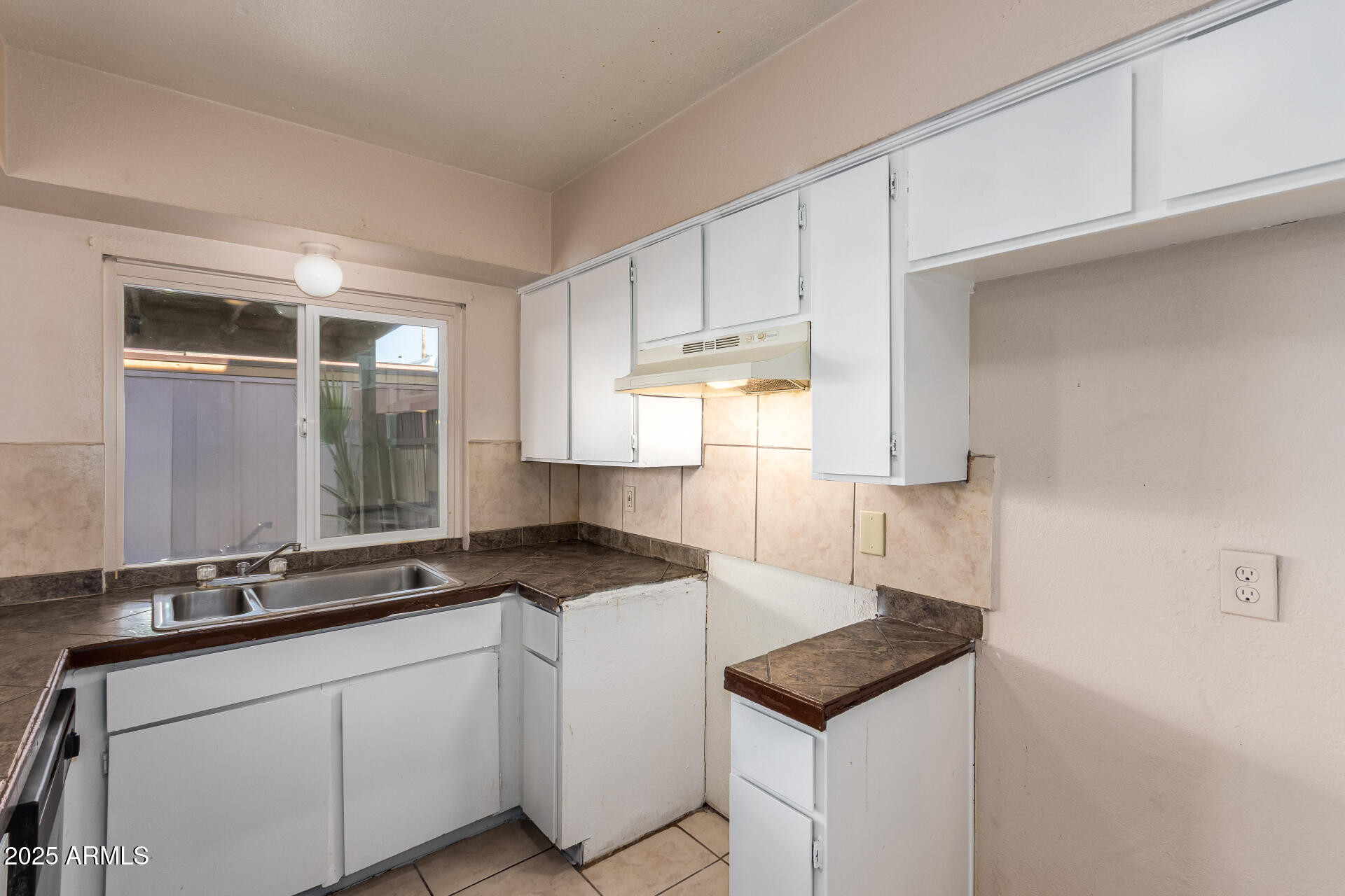 4625 West Thomas Road, Unit 43 Phoenix, AZ 85031 - Photo 9 of 26 a kitchen with granite countertop a sink a stove and cabinets