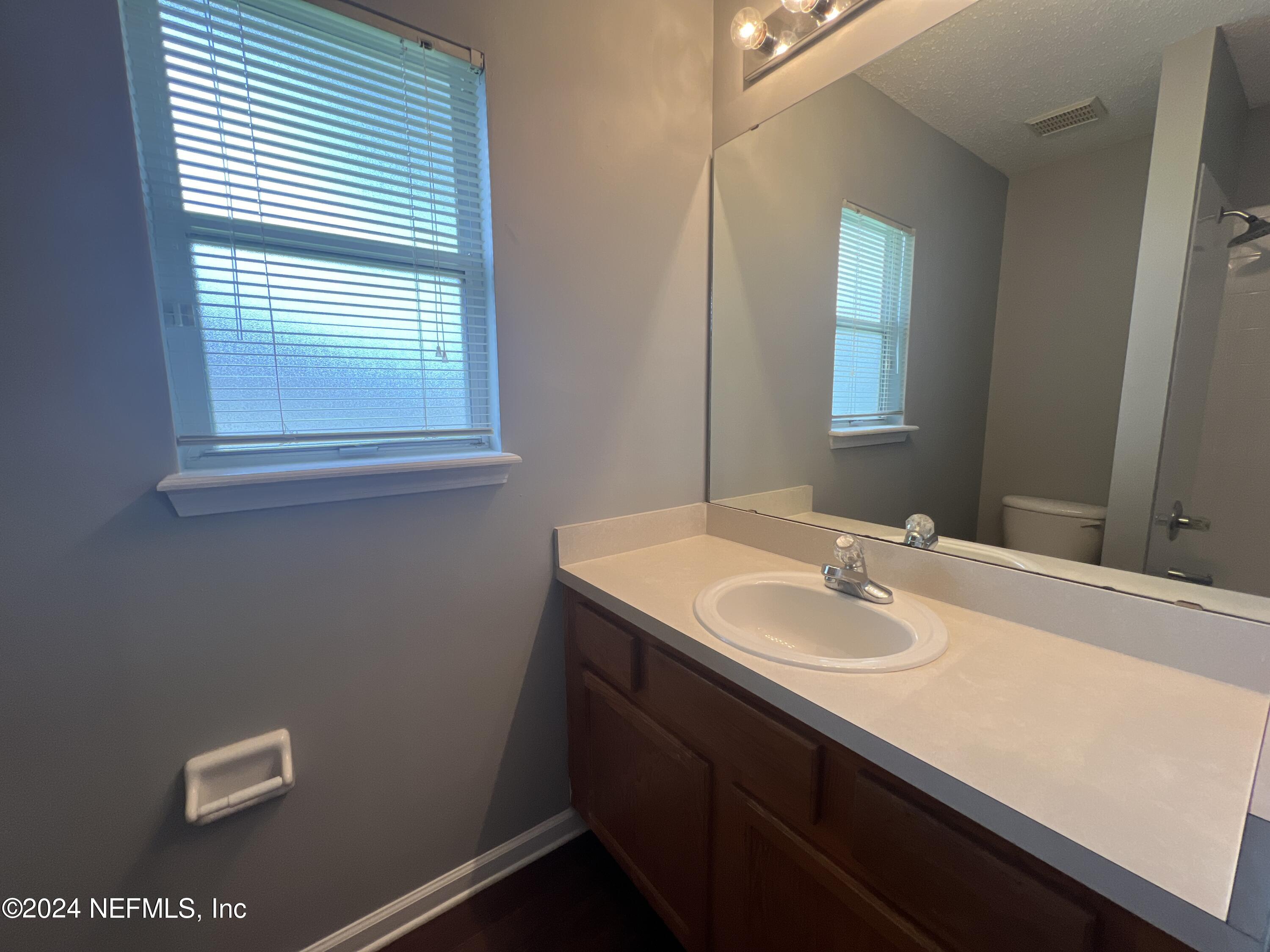 1402 Samantha Circle East Jacksonville, FL 32218 - Photo 27 of 33 a bathroom with a sink a vanity and a mirror
